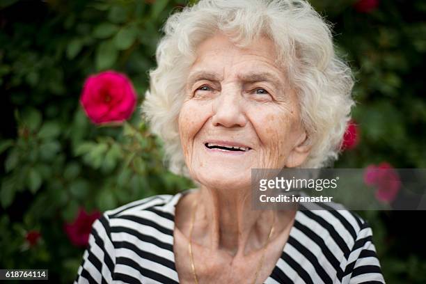 nahaufnahme porträt einer lächelnden seniorin, 80-89 jahre - 80 89 years stock-fotos und bilder