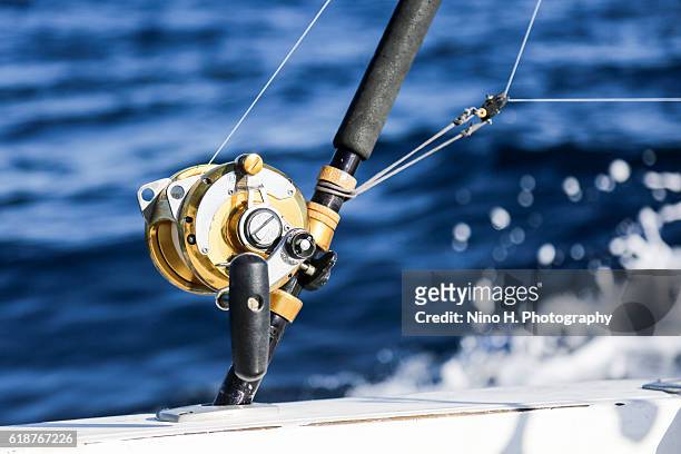 fishing rod sticking out over the ocean - fishing reel stock pictures, royalty-free photos & images