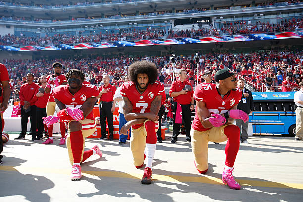 Eli Harold, Colin Kaepernick and Eric Reid of the San Francisco 49ers kneel for the anthem prior to the game against the Tampa Bay Buccaneers at Levi...