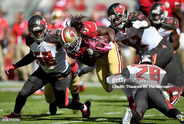 DuJuan Harris of the San Francisco 49ers carries the ball and gets tackled by Vernon Hargreaves and William Gholston of the Tampa Bay Buccaneers...