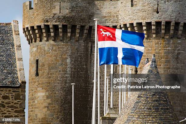 saint-malo city flag in front of old solidor tower. - saint malo stock pictures, royalty-free photos & images