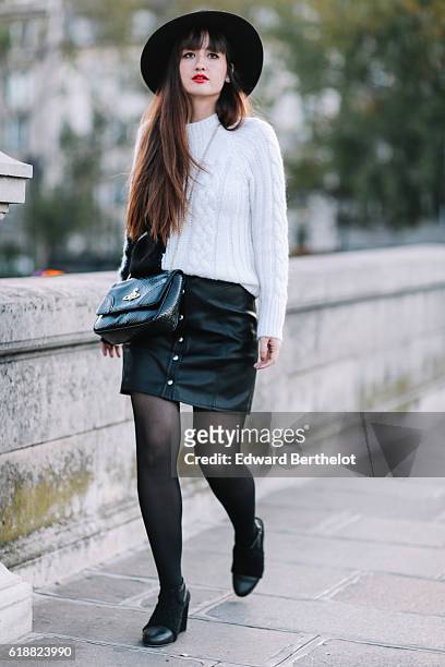 Nikita Wong , is wearing a black hat, an IKKS black and white pull over, a Les Petites black skirt, a Vivienne Westwood bag, and Oui Gal black shoes,...