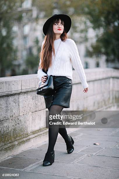 Nikita Wong , is wearing a black hat, an IKKS black and white pull over, a Les Petites black skirt, a Vivienne Westwood bag, and Oui Gal black shoes,...
