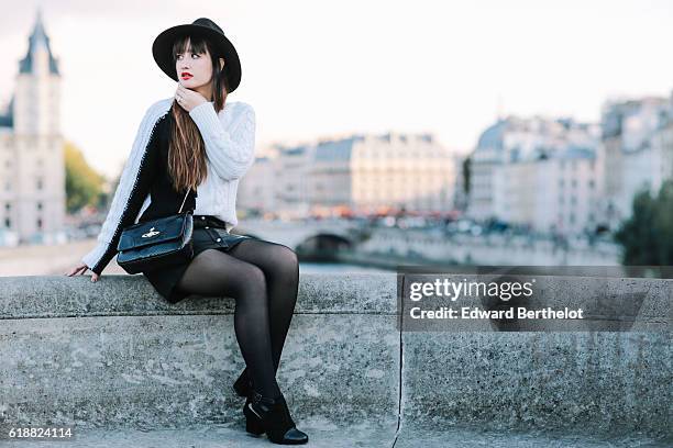 Nikita Wong , is wearing a black hat, an IKKS black and white pull over, a Les Petites black skirt, a Vivienne Westwood bag, and Oui Gal black shoes,...