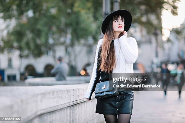 Nikita Wong , is wearing a black hat, an IKKS black and white pull over, a Les Petites black skirt, a Vivienne Westwood bag, and Oui Gal black shoes,...