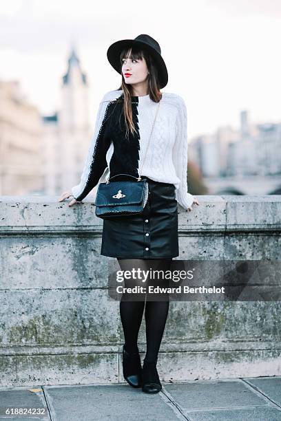 Nikita Wong , is wearing a black hat, an IKKS black and white pull over, a Les Petites black skirt, a Vivienne Westwood bag, and Oui Gal black shoes,...