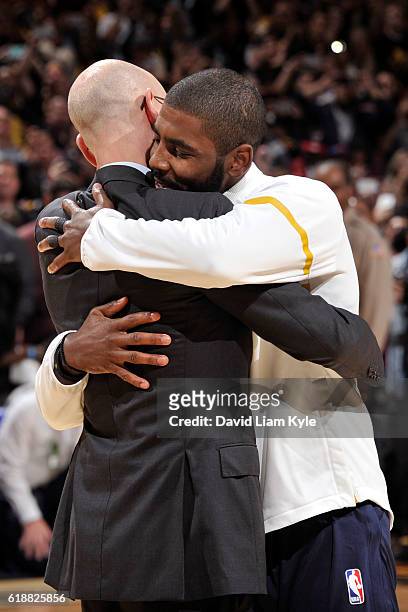 Commissioner, Adam Silver hugs Kyrie Irving of the Cleveland Cavaliers after presenting him with his championship ring before the game against the...