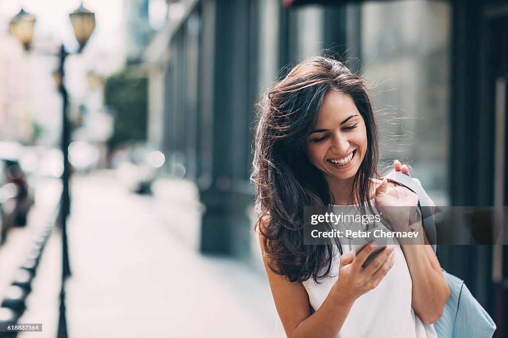 Beautiful woman texting on the street