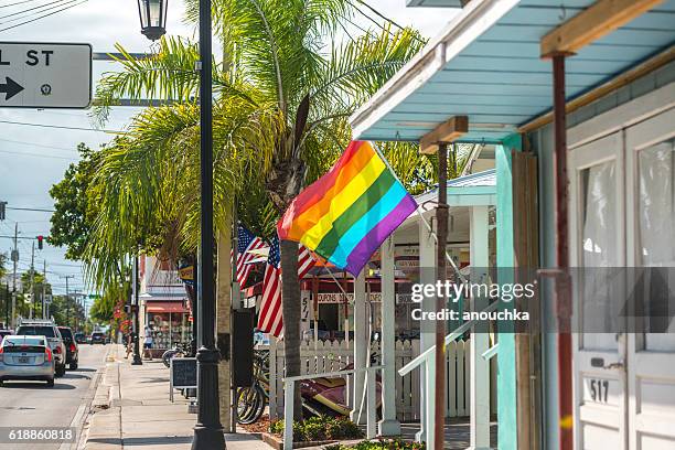 rainbow flag on a house, key west, florida, usa - duval street stockfoto's en -beelden