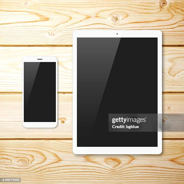 smartphone and tablet pc with blank screen on wooden background - computer desk from above stock illustrations