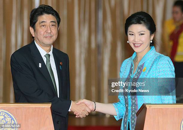 Thailand - Japanese Prime Minister Shinzo Abe and Thai Prime Minister Yingluck Shinawatra shake hands at the end of their joint press conference...