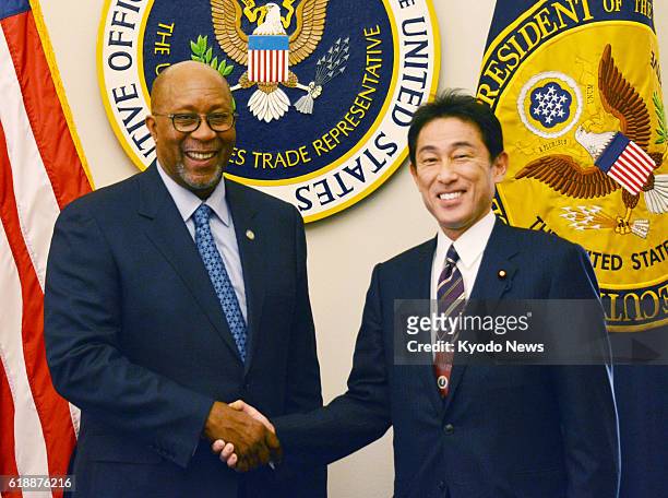 United States - Japanese Foreign Minister Fumio Kishida shakes hands with U.S. Trade Representative Ron Kirk at Kirk's office in Washington on Jan....