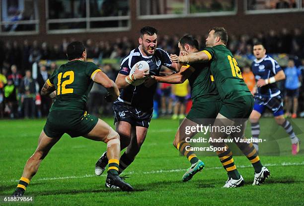 Scotland's Adam Walker is tackled by Australia's Tyson Frizell, Australia's Cameron Smith and Australia's Trent Merrin during the Four Nations match...