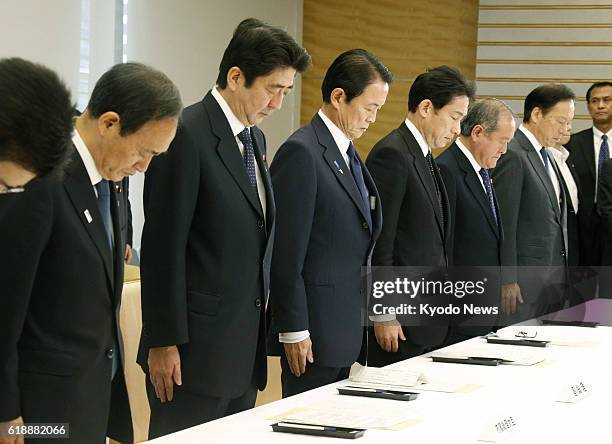 Japan - Japanese Prime Minister Shinzo Abe and other attendees observe a moment of silence at the outset of a meeting of the government's task force...