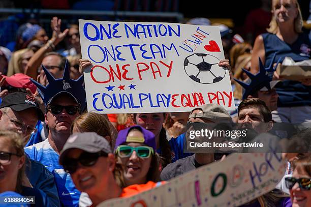 Fan holds and equal play equal pay sign during an international friendly soccer match between South Africa and USA at Soldier Field in Chicago, IL....