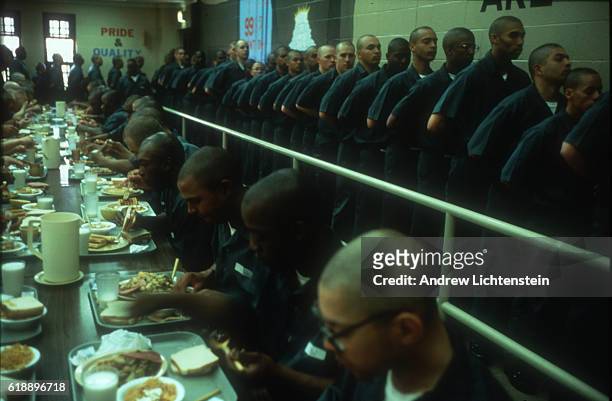 Prisoners line up to eat at a "Shock Camp" prison in upstate, New York n 1997. For eligible non-violent offeders with sentences under three years,...