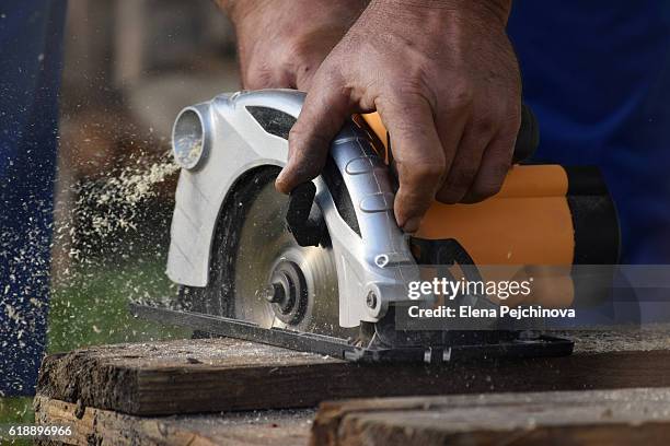 carpenter cutting wood with circular saw - circular saw stockfoto's en -beelden