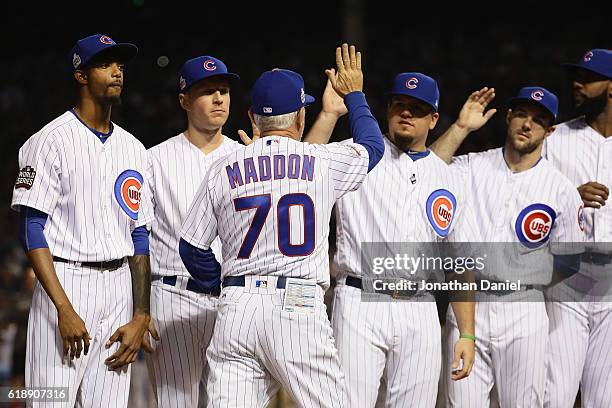 Manager Joe Maddon of the Chicago Cubs gets high fives from his team during player introductions before Game Three of the 2016 World Series against...