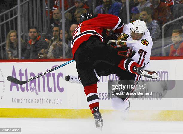 Taylor Hall of the New Jersey Devils checks Marian Hossa of the Chicago Blackhawks during the second period at the Prudential Center on October 28,...