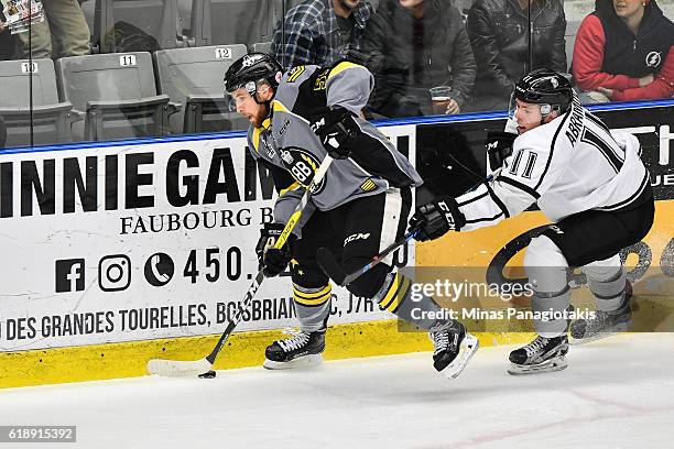 Pascal Corbeil of the Blainville-Boisbriand Armada skates the puck against Vitalii Abramov of the Gatineau Olympiques during the QMJHL game at the...