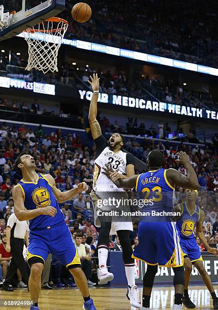 Anthony Davis of the New Orleans Pelicans shoots over Draymond Green of the Golden State Warriors and Zaza Pachulia during the first half of a game...