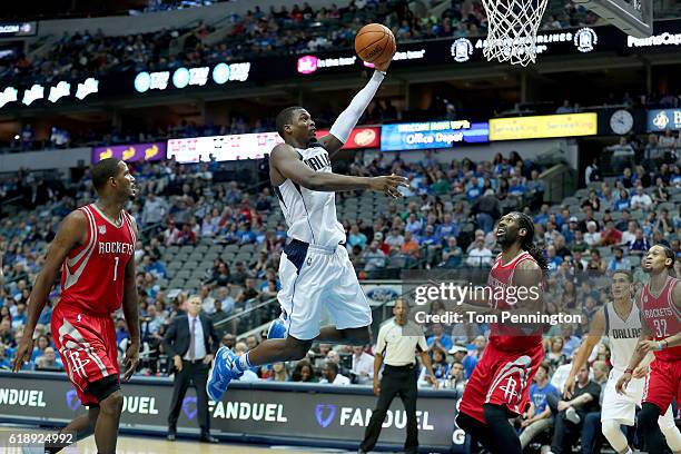 Harrison Barnes of the Dallas Mavericks drives to the basket against Trevor Ariza of the Houston Rockets and Nene Hilario of the Houston Rockets in...