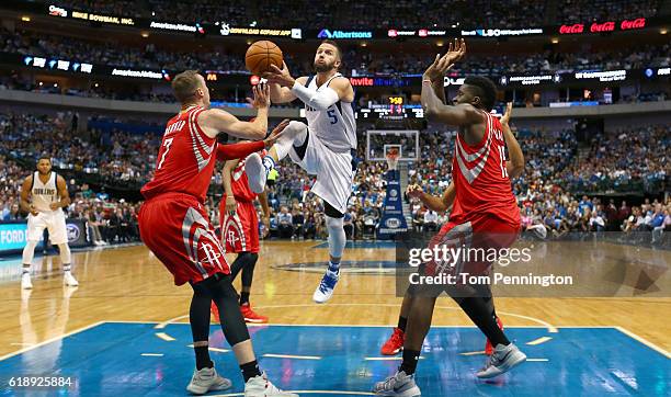 Barea of the Dallas Mavericks drives to the basket against Sam Dekker of the Houston Rockets and Clint Capela of the Houston Rockets in the first...