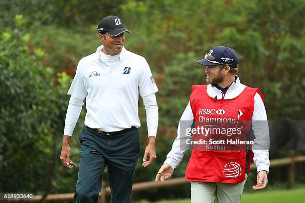 Matt Kuchar of the United States celebrates a hole in one on the 17th hole with caddie John Wood during day three of the WGC - HSBC Champions at...