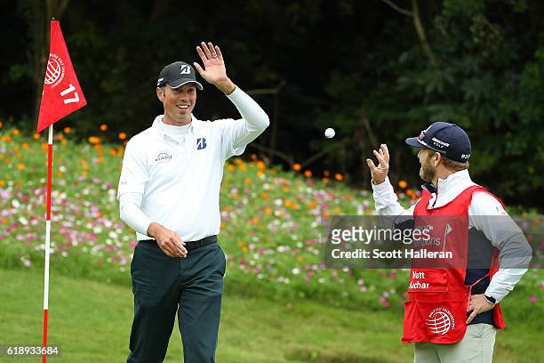 Matt Kuchar of the United States celebrates a hole in one on the 17th hole with caddie John Wood during day three of the WGC - HSBC Champions at...