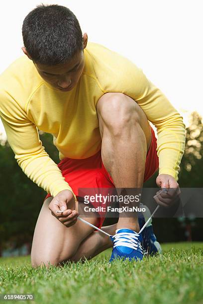 runner tying shoes in park - too small stock pictures, royalty-free photos & images