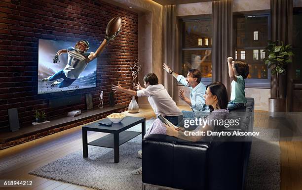 family with children watching american football game on tv - tv family stockfoto's en -beelden