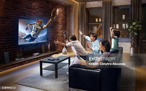 family with children watching american football game on tv - american football sport stock pictures, royalty-free photos & images
