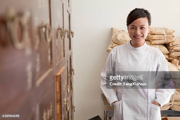 portrait d’un médecin en médecine traditionnelle chinoise avec cabinet - médecine chinoise par les plantes photos et images de collection