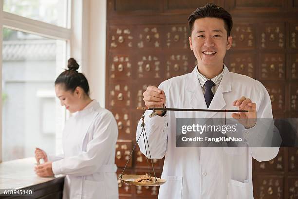 traditional chinese medicine doctor using scale - chinese herbal medicine stock pictures, royalty-free photos & images