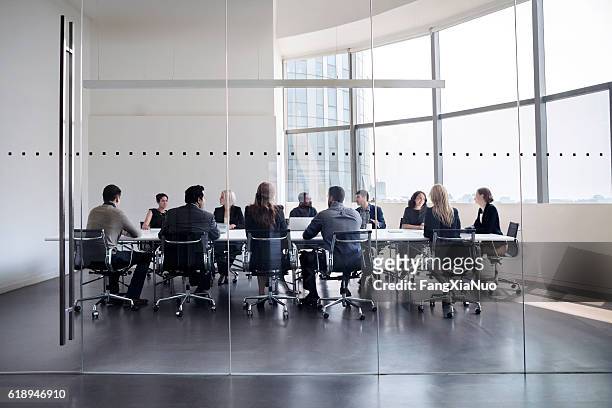 colleagues at business meeting in conference room - business meeting stockfoto's en -beelden