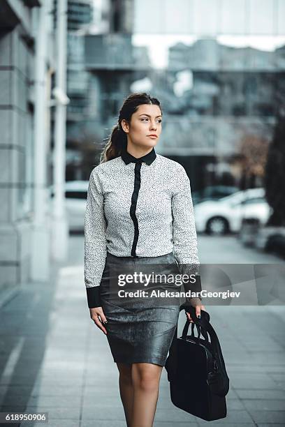 brunette businesswoman with laptop bag walking outdoor on street - long skirt stock pictures, royalty-free photos & images