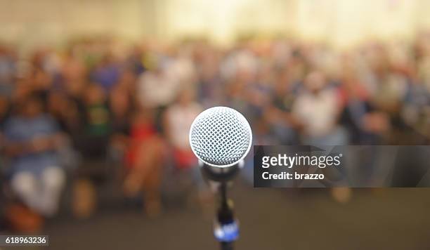 empty microphone in front of a crown of people - poet stock pictures, royalty-free photos & images