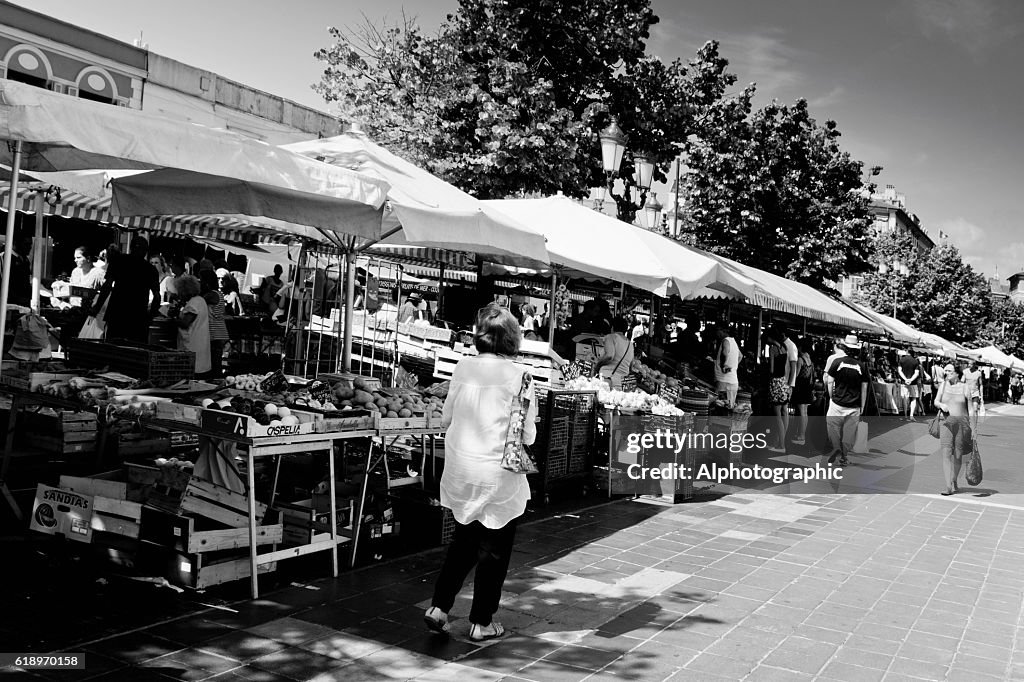 Tourists walking past market stalls.