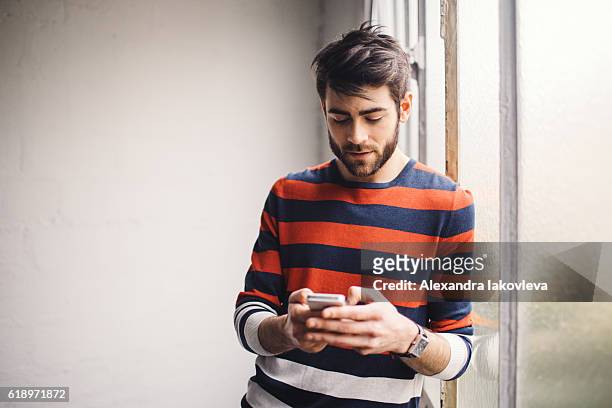 junger mann plaudern am telefon - modern boy hipster stock-fotos und bilder