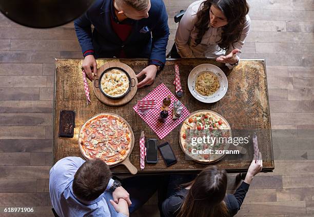 friends eating pizza, elevated view - pub food stock pictures, royalty-free photos & images