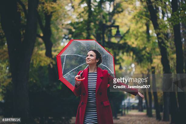 schöne junge frau genießt einen regnerischen tag - female with umbrella stock-fotos und bilder