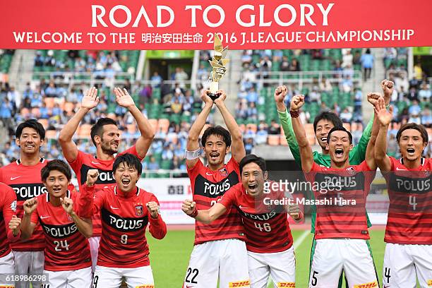 Captain Yuki Abe of Urawa Red Diamonds lifts the trophy after winning the J.League second stage after the J.League match between Jubilo Iwata and...