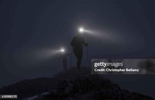 hiking up ridge in darkness - mountain ridge stock pictures, royalty-free photos & images
