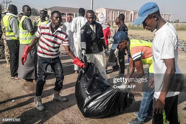 Graphic content / Emergency personnel carry remains of victims of two suicide bombings in Nigeria's northeast city of Maiduguri on October 29, 2016...