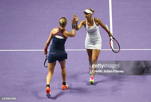 Elena Vesnina and Ekaterina Makarova of Russia celebrate a point in their doubles semi-final against Martina Hingis of Switzerland and Sania Mirza of...