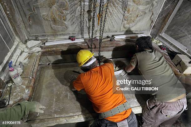 Greek preservation experts place back the marble slab stone that covered the Tomb of Jesus, where his body is believed to have been laid, after it...