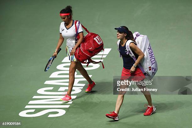 Sania Mirza of India and Martina Hingis of Switzerland look dejected as they leave the court after their doubles semi-final against Elena Vesnina and...