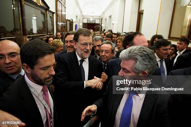 Acting Spanish Prime Minister Mariano Rajoy is congratulated after winning the investiture debate as he leaves the Spanish Parliament on October 29,...