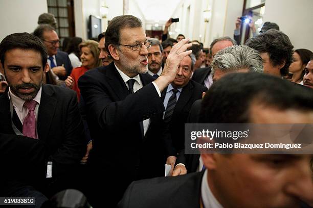Acting Spanish Prime Minister Mariano Rajoy waves his hand to a supporter after winning the investiture debate as he leaves the Spanish Parliament on...