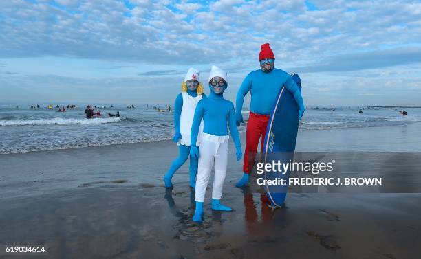 John Witting and his children Hudson and Ruby, dressed as the Smurfs, prepare to hit the water as surfers in costume ride waves at Blackie's 10th...